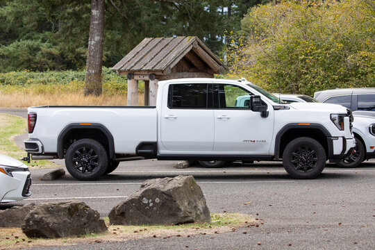 Skamania, WA, USA - Sep 27, 2025 - White GMC Sierra HD AT4 heavy duty pickup truck parked in public parking lot of a forest park, showing modern design and power vehicle built for towing and work use