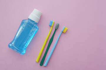 Important dental care items arranged on a pink background