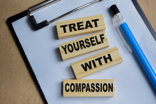 treat yourself with compassion on stacked wooden cubes on the table. Business and finance concept