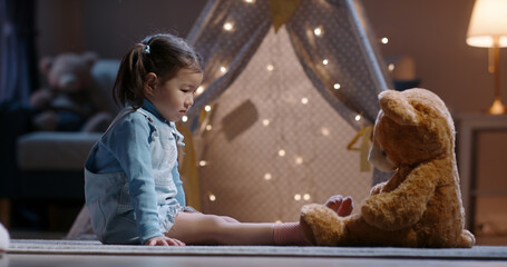 Little girl imagining adventure with teddy bear in glowing tent dreamlike childhood fantasy world full of warmth magic and creativity