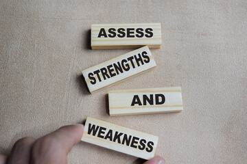 Assess strengths and weakness on stacked wooden cubes on the table. Business and finance concept