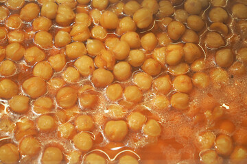 Chickpeas cooking in a large pot with broth and spices