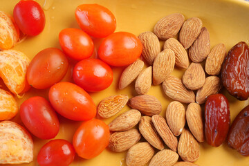 Fresh fruits and nuts arranged on a yellow tray