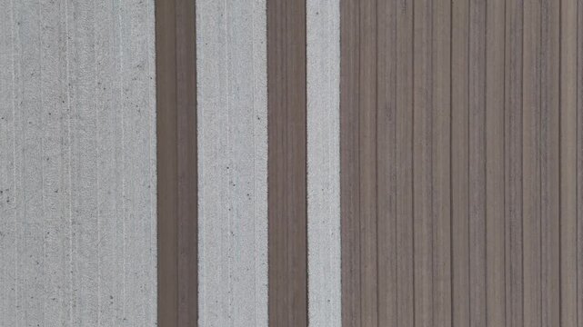 Top down drone view of parallel stretches of plowed and smoothed rural soil, showing fields meticulously prepared and leveled for upcoming planting, with distinct furrow and planting patterns visible
