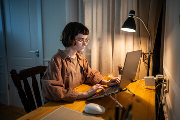 Overload female professional type on laptop at home with focus. Intense late night work, young...
