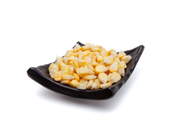 Yellow corn in a black container on white background