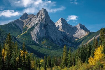 Fototapeta premium Jagged peaks rise over green, yellow, autumn forest