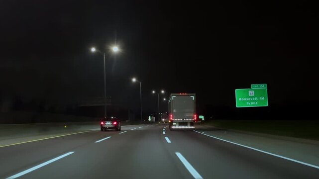 Overtaking the truck with white trailer on the highway during the night time. Wide POV 