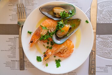 An overhead view presents a delicious seafood feast featuring mussels and shrimp on a white plate. The vibrant colors and fresh ingredients highlight the dish s appeal for culinary publications.