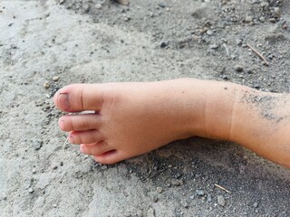 close-up of a girl's tiny feet dirty from playing in the sand