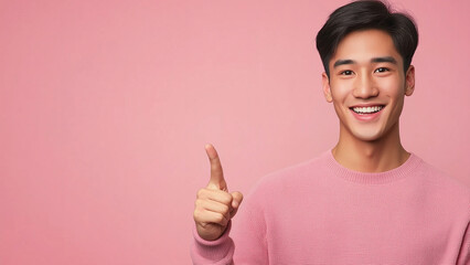 Smiling Asian man pointing a finger, copy space