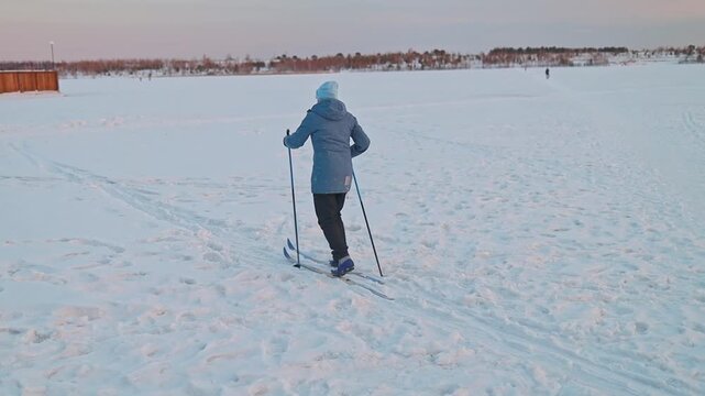 Back view of a woman falling while cross-country skiing. Sports Injuries, Sprains, Fractures