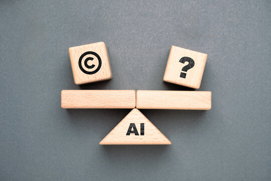Wooden blocks with AI, copyright, and question mark icons arranged on a balance scale representing copyright challenges, legal uncertainty, and ethics in artificial intelligence