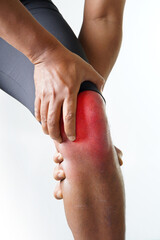 Man experiencing intense knee pain from sports injury and seeking relief with hands resting on joint