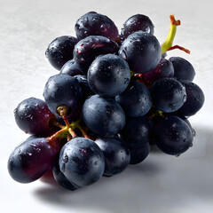 Fresh Black Grapes in a Compact Cluster with Raindrops on a Light Background