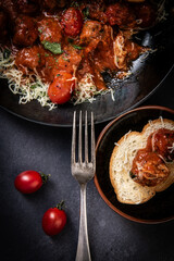 Meatballs with tomato sauce and parmesan cheese on dark background