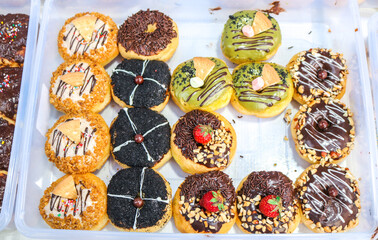 Donuts with various flavors and toppings. A donut shop that sells various donut flavors.