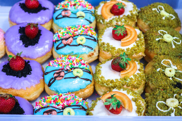 Donuts with various flavors and toppings. A collection of donuts arranged in a container.