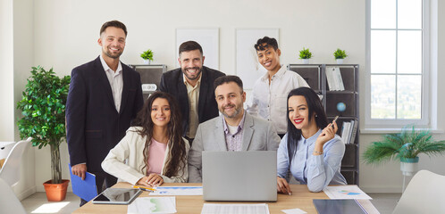Business people team in office meeting portrait. Colleagues group smile around laptop, showing collaboration, teamwork and leadership in workspace. Ready for strategy and planning discussions.