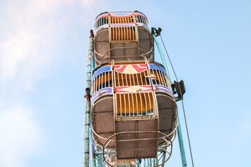Colorful big ferris wheel on blue sky sunset background in funfair festival night market. Close up silhouette of ferris wheel spinning in amusement park
