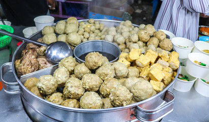 Meatballs in various flavors in a steamer. Meatballs in various sizes and tofu.