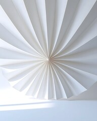 White paper fan unfolds against a white wall, casting soft shadows and creating a minimalist and serene atmosphere.