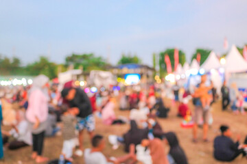 Abstract blur people in night festival city park bokeh background. Blurry photo of crowd of people in night market with food stalls