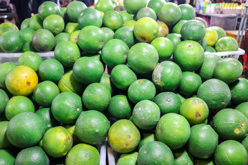 A large pile of squeezed oranges is arranged on a shelf.