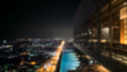 Obraz premium Burred a balcony overlooking an illuminated cityscape under a twilight sky. Blurred room