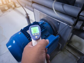 Checking the temperature of an electric motor using an infrared thermo gun.