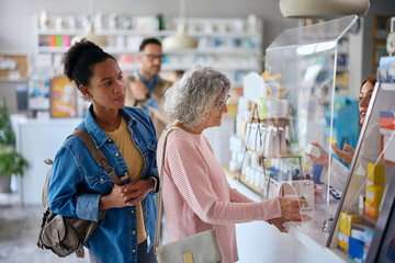 Impatient black woman waiting in line in pharmacy.