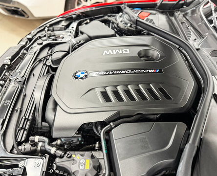 The M Performance Engine Cover With BMW Badge And Branding Of A B58 Turbocharged Engine In A BMW M140i Hatchback. BMW sport engine or motor under vehicle hood.