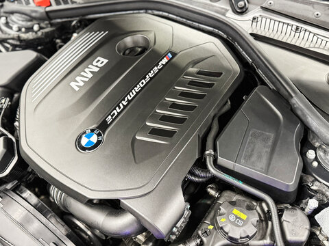 The M Performance Engine Cover With BMW Badge And Branding Of A B58 Turbocharged Engine In A BMW M140i Hatchback. BMW sport engine or motor under vehicle hood.