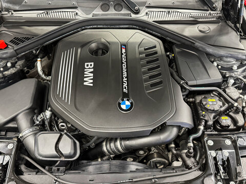 The M Performance Engine Cover With BMW Badge And Branding Of A B58 Turbocharged Engine In A BMW M140i Hatchback. BMW sport engine or motor under vehicle hood.