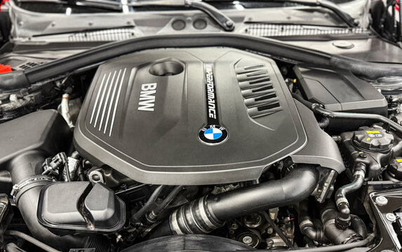 The M Performance Engine Cover With BMW Badge And Branding Of A B58 Turbocharged Engine In A BMW M140i Hatchback. BMW sport engine or motor under vehicle hood.