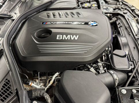 The M Performance Engine Cover With BMW Badge And Branding Of A B58 Turbocharged Engine In A BMW M140i Hatchback. BMW sport engine or motor under vehicle hood.
