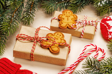 Christmas card with fir branches, gifts and cookies on beige surface