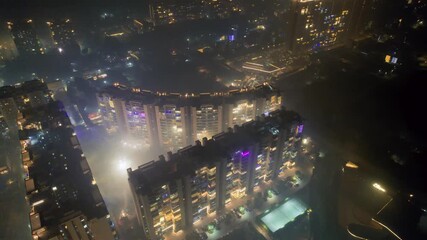 aerial drone shot of skyscrapers decorated with lights for Diwali with fireworks being set off all around for the celebrations hidden by the smoke fog smog in Gurgaon Delhi - Powered by Adobe