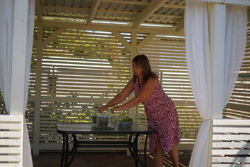 A woman canning cucumbers in jars