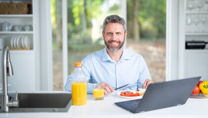 Healthy nutrition mature man. Caucasian man with healthy products at kitchen. Handsome Senior Man Eating Tasty Meal In Kitchen At Home. Elderly Man at Table Enjoying Delicious Food. Morning breakfast.