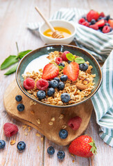 Healthy breakfast granola with fresh berries and honey