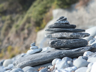 Big and small pyramid of marble stones against mountain backdrop on sunny day. Balance of mental health and meditation. Caring for body.