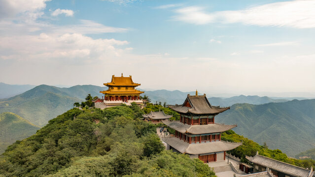 Ancient chinese temple complex perched atop a mountain under a blue sky