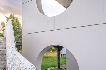 Modern White Architecture With Circular Openings and Geometric Design Elements, View Through Arch to Green Park