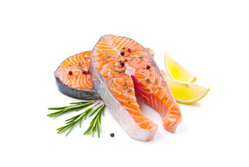 Fresh salmon steaks, spices and lemon slices on white background