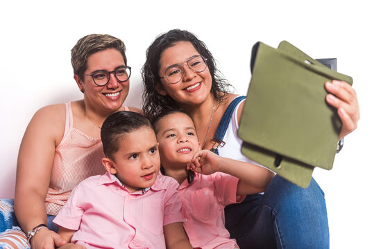LGBTQ family taking selfie with tablet while sitting together.
