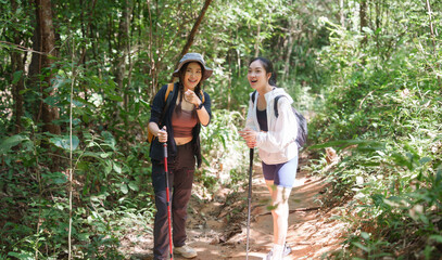 Young women hiking trail in lush green forest