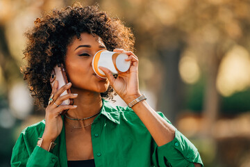 young latina woman on the street drinking