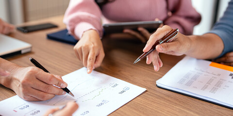 group of colleagues in formal clothing discussing business ideas while gathering at table in modern...