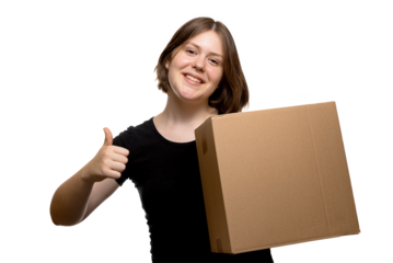 Positive young woman holding a cardboard box and showing thumbs up gesture on transparent background.